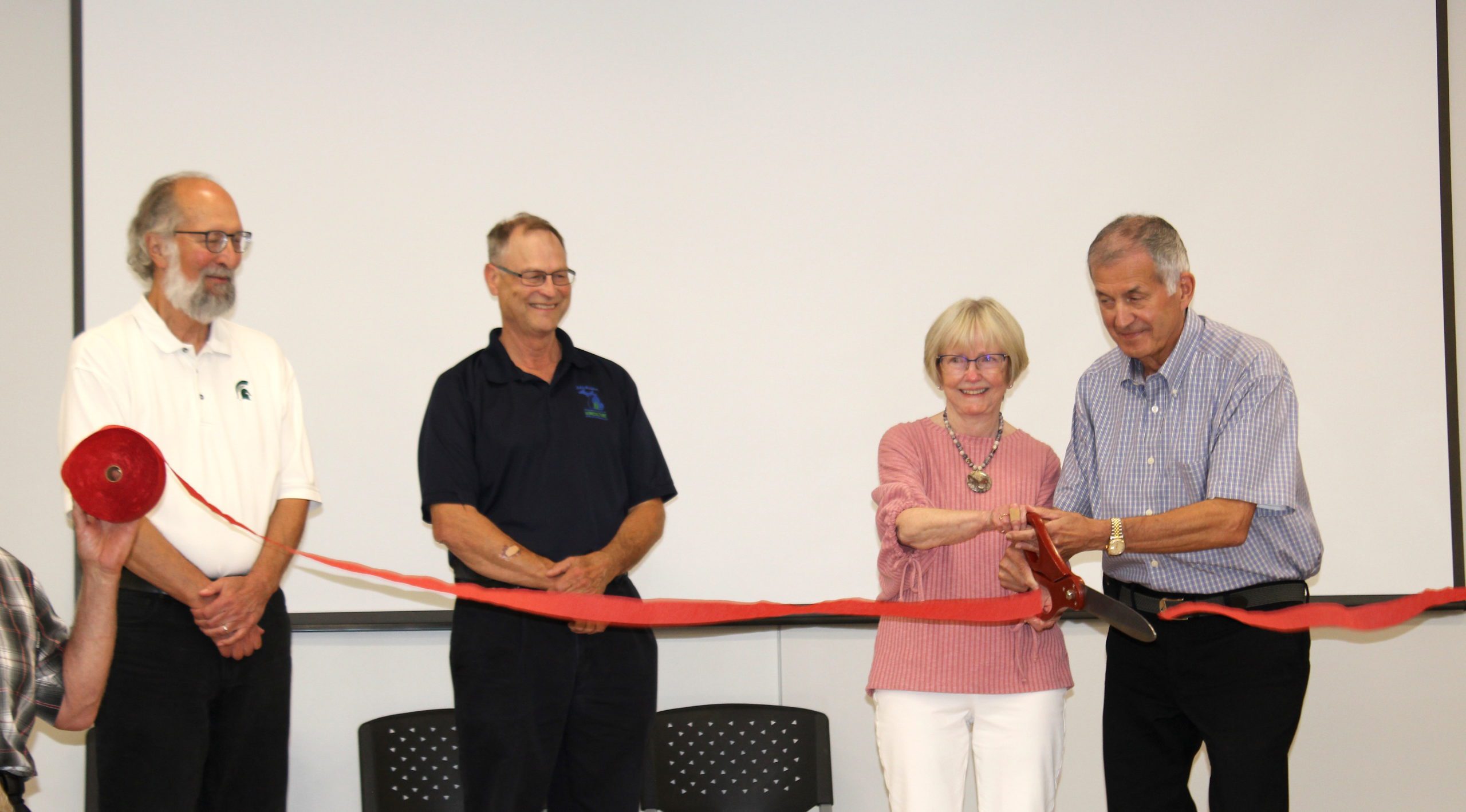 Earl and Linda Peterson cut the ribbon at the new research station that bears their name. with them are MSU’s Doug Buhler, left, and Michigan Department of Agriculture and Rural Development Director Gary McDowell.