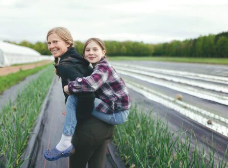 A woman in black with a little girl on her back