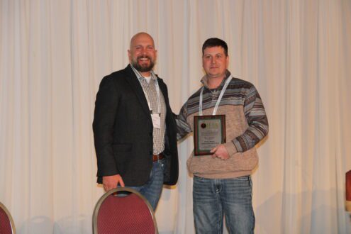 Brett Kast of Kast Farms, left, presents Bobby Brown of Orchard Dale Fruit in Waterport, New York, International Fruit Tree Association’s IFPA’s Outstanding Grower of the Year Award.