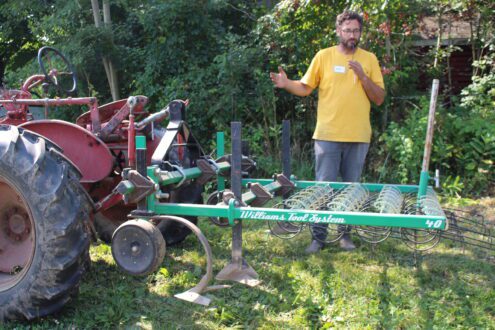 Man in front of tractor equipment attachment.