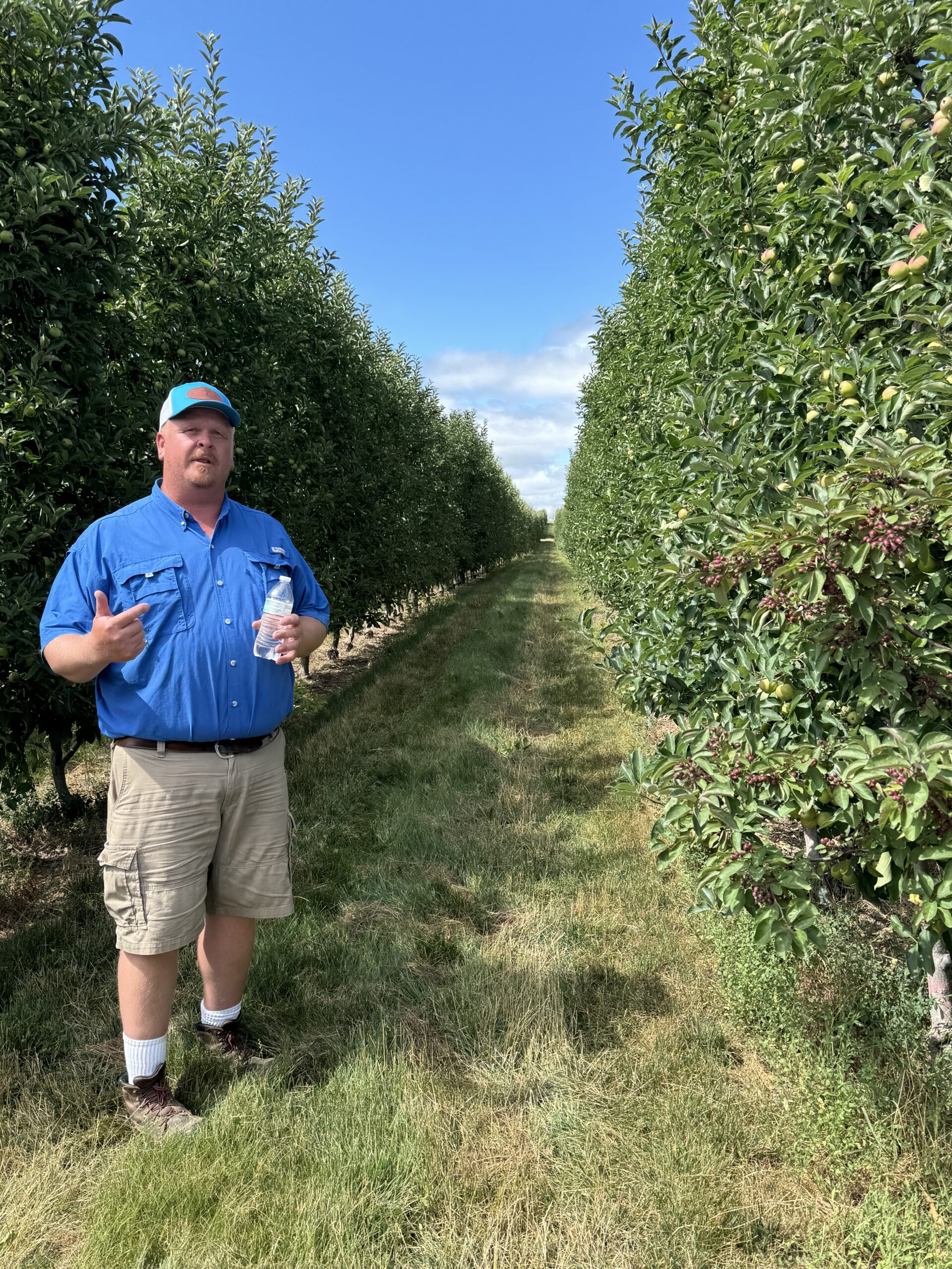 Photo of Bill Nyblad addressing Ridgefest participants in an orchard.