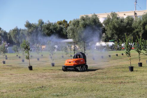 Robotic ag equipment spraying trees.