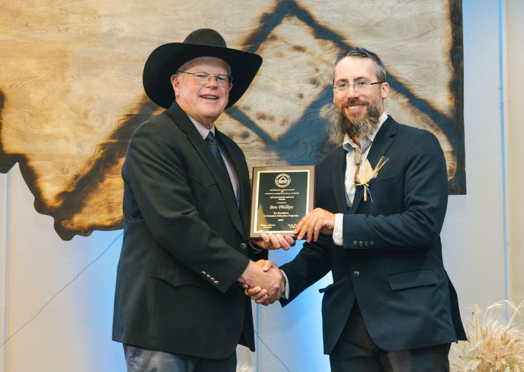 Photo of National Association of County Agricultural Agents’ Scott Jensen presenting Ben Phillips the organization’s distinguished service award.
