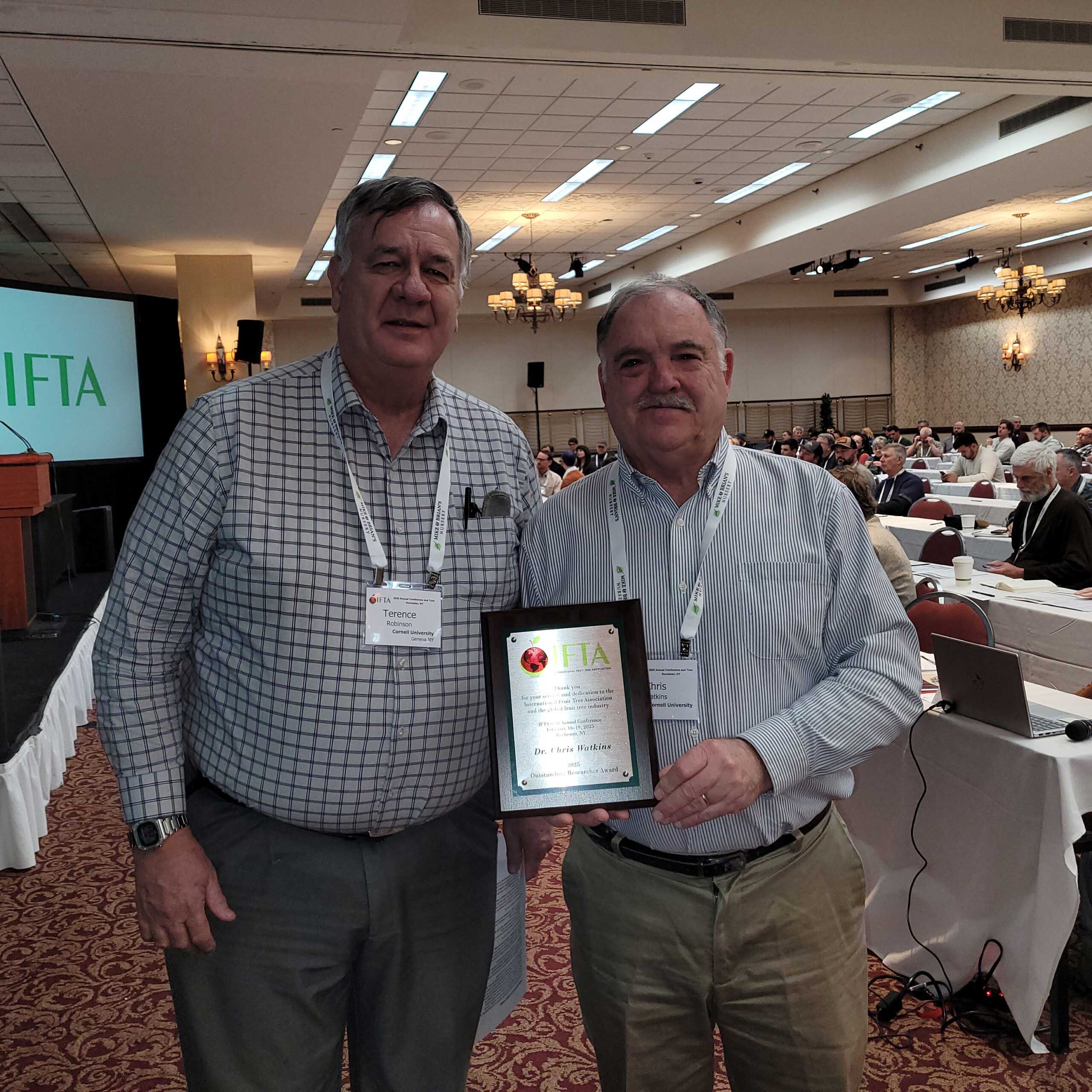 Cornell’s Terence Robinson, left, presented Christopher Watkins, a professor in Cornell’s School of Integrative Plant Science, with International Fruit Tree Association’s IFPA’s Outstanding Researcher Award.