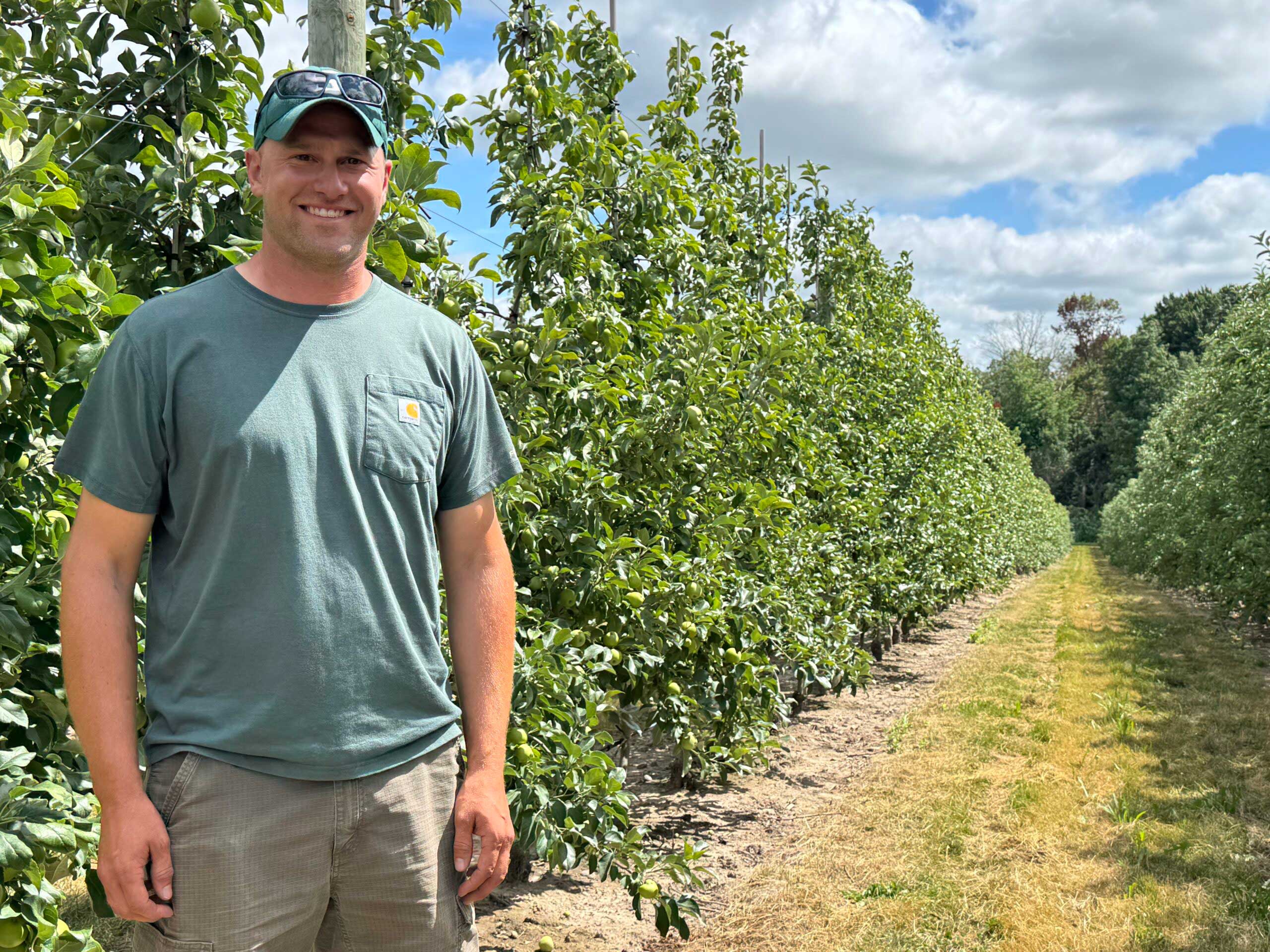 Photo of Nick Rasch addressing Ridgefest participants in an orchard.