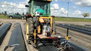 Farm machinery spraying weeds in a field.